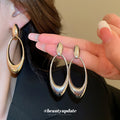 Open Oval Sculptural Drop Earrings In Gold And Silver Tone view 2