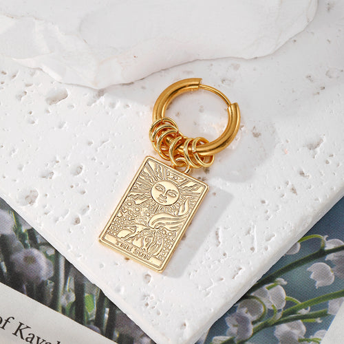 Close-up showing the colors and surface details of gold Tone Tarot Cross and Celtic Knot Multi Charm Hoop Earrings
