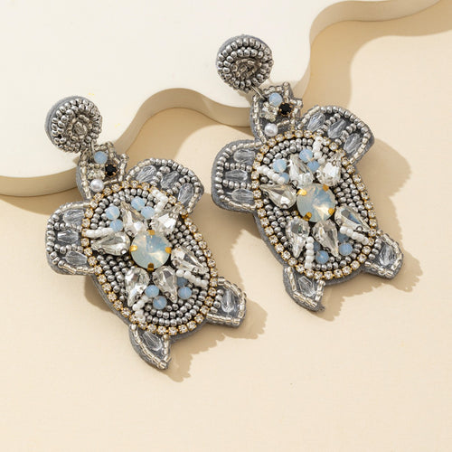 Silver-tone beaded turtle drop earrings with clear rhinestone accents