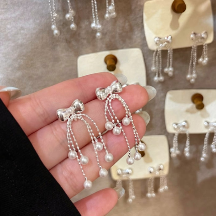 Silver Tone Bow and Pearl Chain Tassel Earrings With Decorative Details