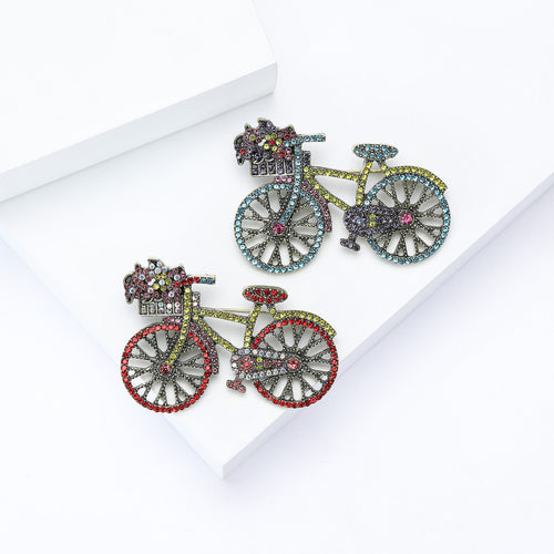 Red and blue rhinestone bicycle brooches on white blocks