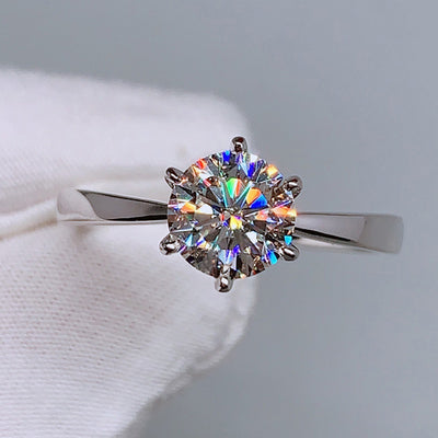 Silver six prong solitaire clear CZ ring held with white glove