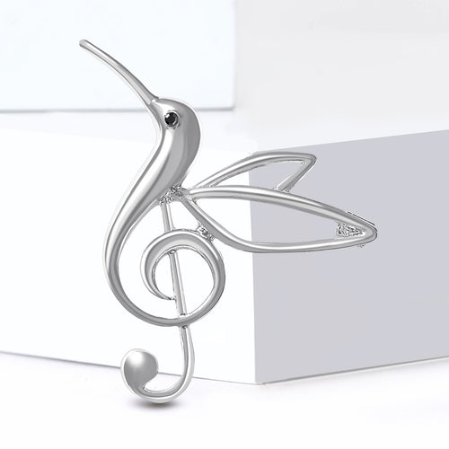 Silver tone hummingbird treble clef brooch on white blocks