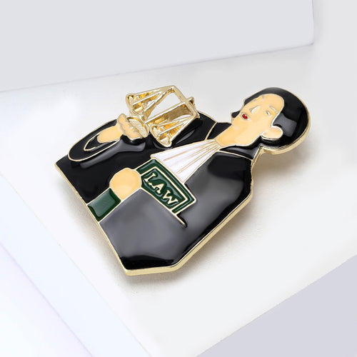 Lawyer brooch angled on white blocks showing scales