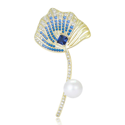 Blue gold ginkgo leaf brooch with pearl drop on white background