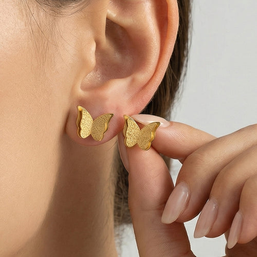 On-ear view of matte double layer butterfly stud earrings in main image 2.