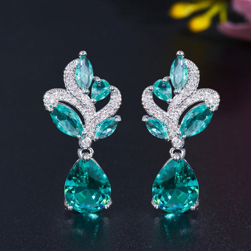 Pair of silver aqua teal leaf pear drop earrings on dark surface