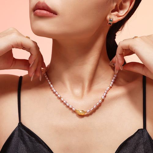 Model adjusting lavender pearl necklace with gold center bead