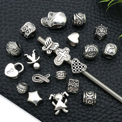 Metallic cross and heart beads shown in a close-up product view