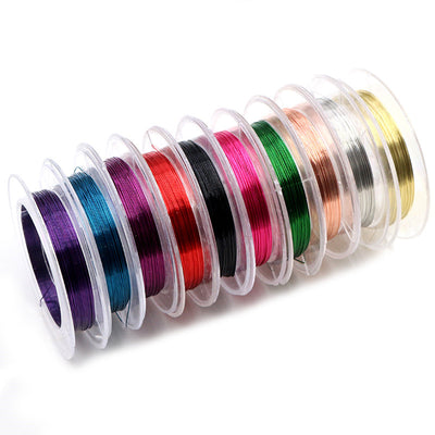 Overview of assorted fine craft wire wound on compact clear plastic spools on a light background