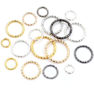 Assorted textured twist jump rings in mixed sizes and finishes arranged together in the main product view
