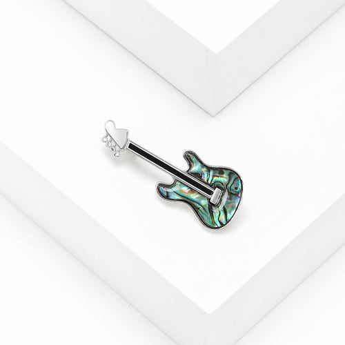 Close-up product view showing the colors and surface details of the green guitar brooch
