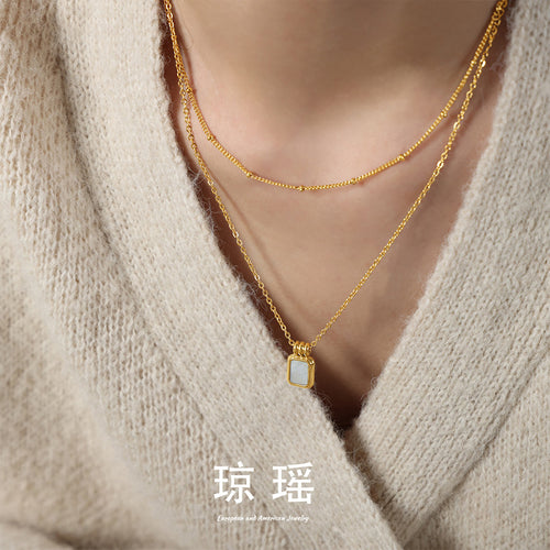 Model wearing gold double-layer rectangular white shell pendant necklace