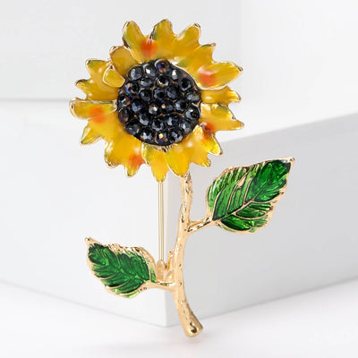 A yellow sunflower with a dark center and two green leaves shown on a white background.