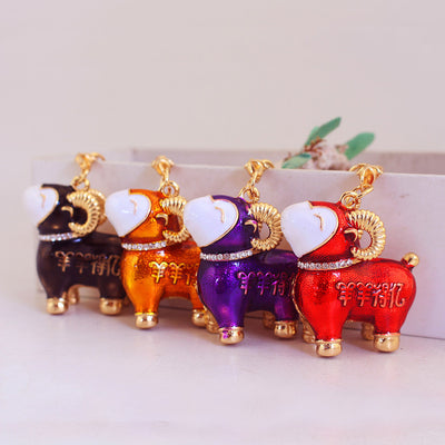 Four ram charms in black, orange, purple, and red stand in a row.