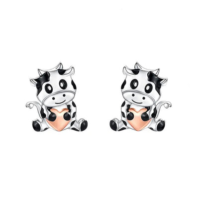 Product view showing small black-and-white cow figures with peach-colored bellies