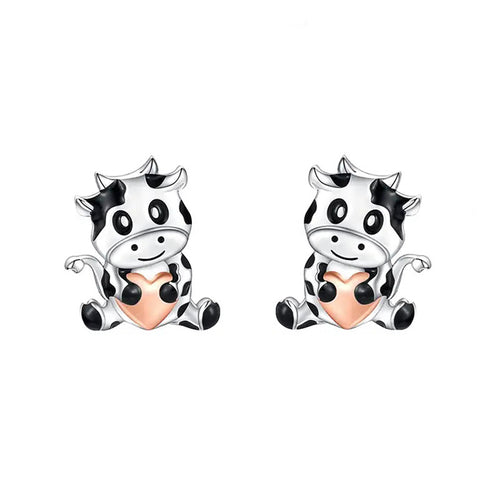 Product view showing small black-and-white cow figures with peach-colored bellies