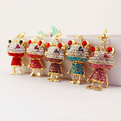 Five gold-tone rhinestone frog keychains arranged in a row.