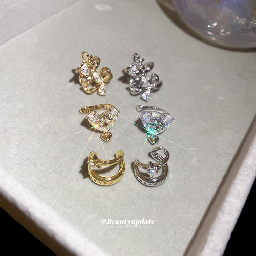 Styled view of star and butterfly crystal ear cuffs in six mixed metal styles