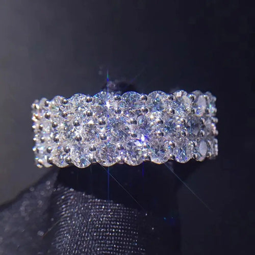 Front face of triple row round CZ band ring on black fabric