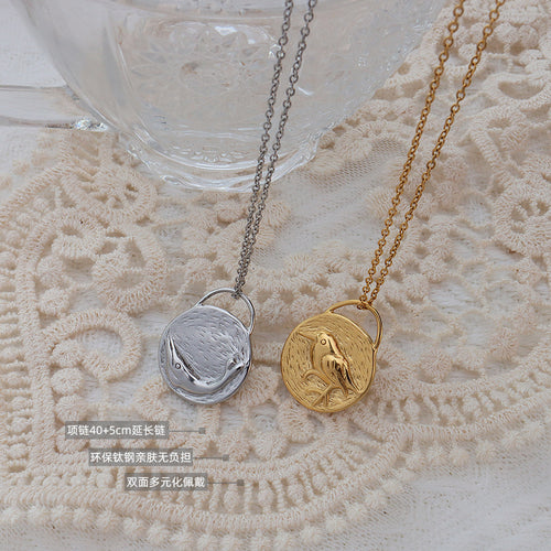 Gold and steel bird dolphin disc pendants flat lay with size labels