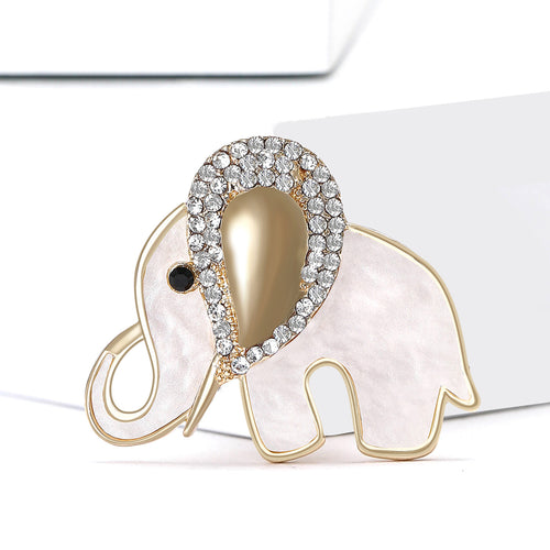 White elephant brooch angled on white blocks studio view