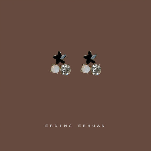 Mini black star dual stone studs on solid brown background