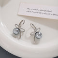 Gold Tone Bow White Pearl Look Ball Huggie Earrings view 3