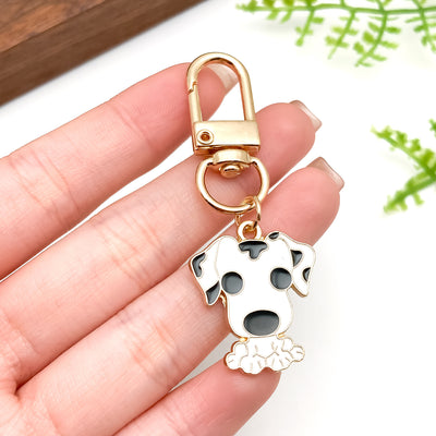 Image 1 showing a person holding up a key chain with a dog charm.