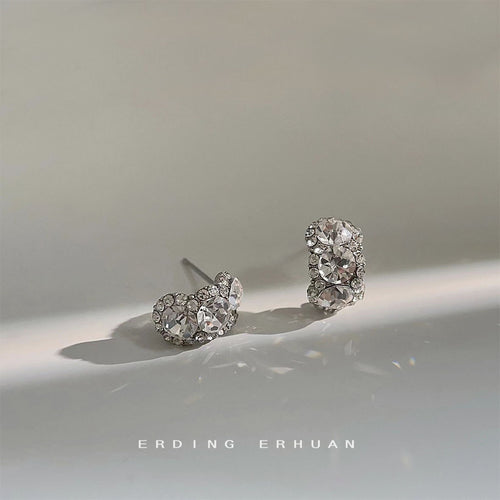 Curved three-stone CZ studs on soft grey surface
