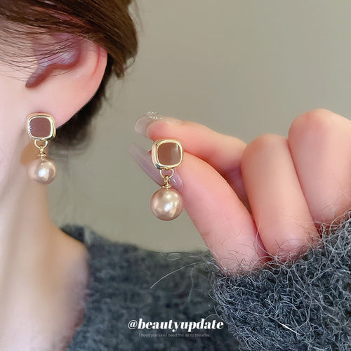 champagne pearl drop stud earrings displayed from a second angle