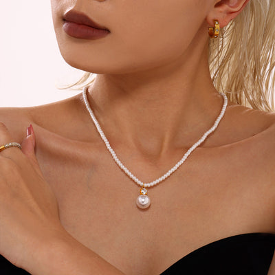 Model wearing white pearl strand large drop pendant gold cap