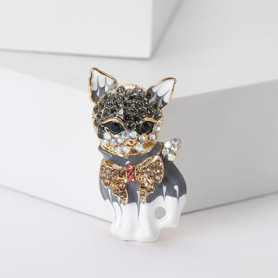 Front view of the gray and white cat brooch with crystal collar decorative clothing pin on a white background