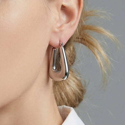 On-ear view of tapered open center hoop earrings in main image 2.