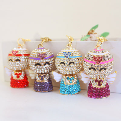 Four rhinestone angel keychains in red, purple, blue, and pink arranged together.