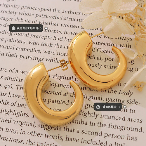 Pair of gold chunky C-shape hoops on book with style plating labels