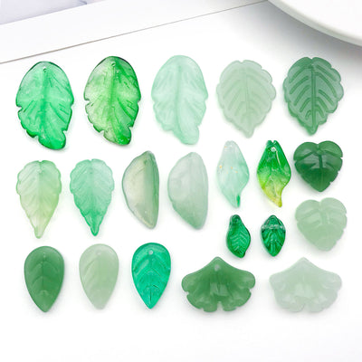 Assorted green glass leaf charms and beads arranged as a full product overview