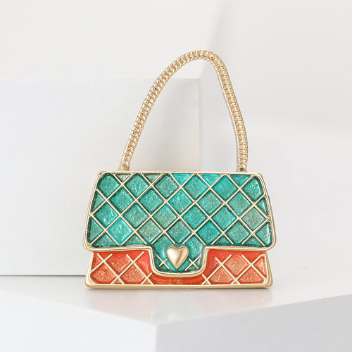 Close-up product view showing the colors and surface details of the green enamel handbag brooch