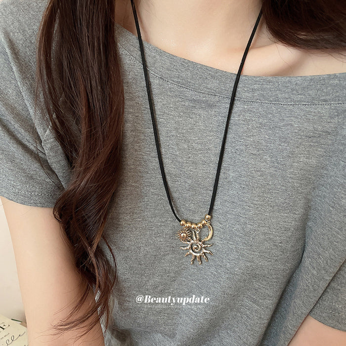 Gold Tone Sun and Moon Pendant Necklace on Black Cord