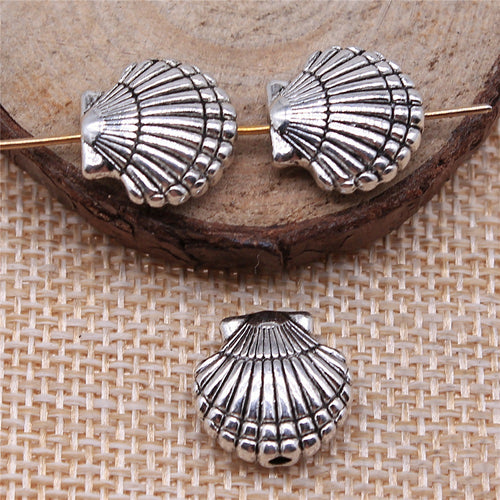 Styled close-up of the scallop shell bead showing ridged scallop shell shape