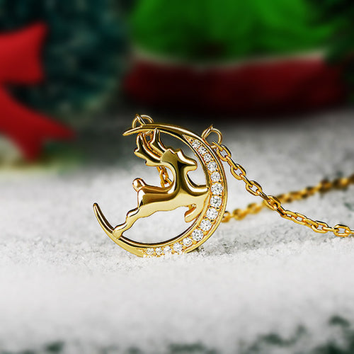 Angled detail view of gold tone reindeer crescent moon pendant necklace with stones