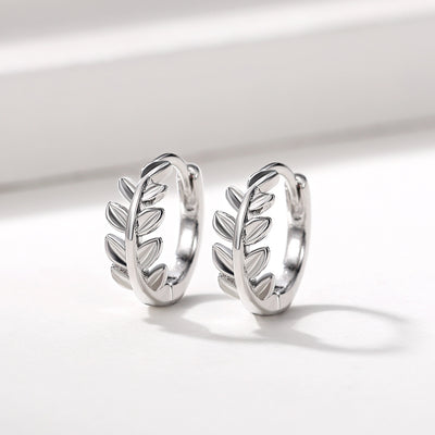 White gold leaf branch huggie hoop earrings pair front product view