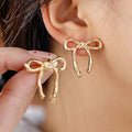 Polished Ribbon Bow Stud Earrings in Gold and Silver view 1