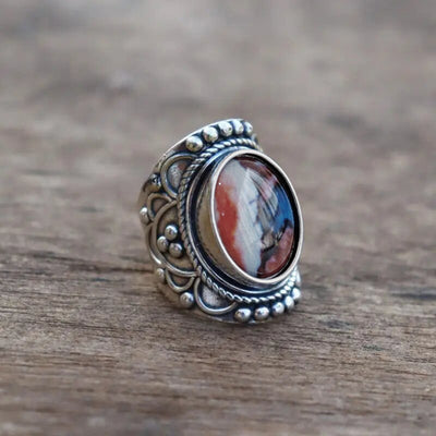 Antique silver floral oval multicolor cabochon ring on wood table