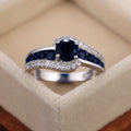 Black And Blue Round Stone Swirl Ring In Four Metal Finishes view 3