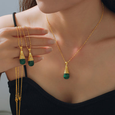 Gold malachite shuttlecock pendant necklace worn and held in hand