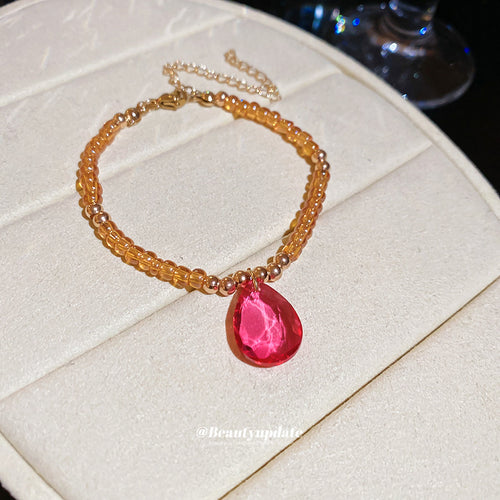 Matching amber bead magenta teardrop pendant bracelet on display
