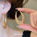Textured Open Oval Huggie Earrings with Polished Metal Tone Details view 4