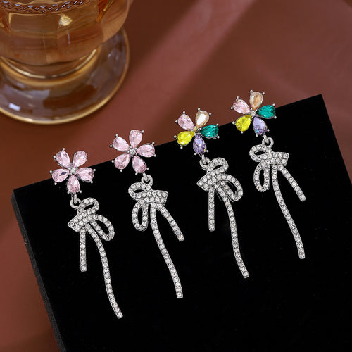 Pink and multicolor flower stud earrings with crystal bow drops on black