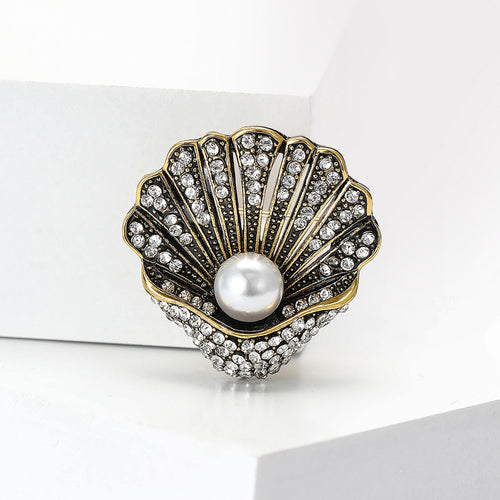 Antique gold shell brooch with pearl center on white display block